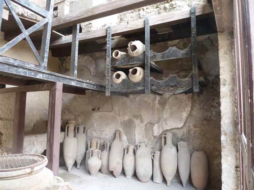 Ins. V.6. May 2010. Shelving and amphorae on south side of shop.